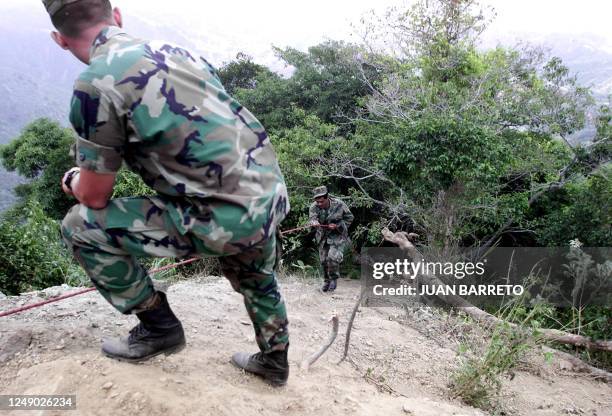 Soldiers are seen at the sight where a military helicopter crashed in the mountains. The newly appointed head of the Venezuelan Air Force and nine...