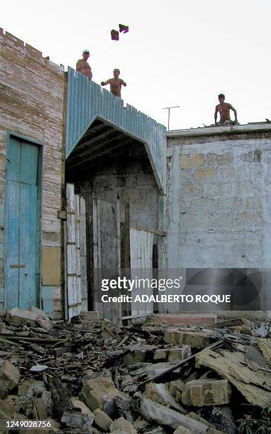 Residents of Colon, Cuba are seen cleaning their rooftops 06 November 2001 after Hurricane Michelle hit their town. Residentes de Colon, Matanzas,...