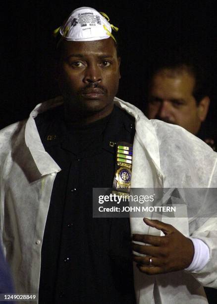 An unidentified police officer leaves the New York City Hospital where refridgeration trucks line the street 12 September, 2001 in preparation for...