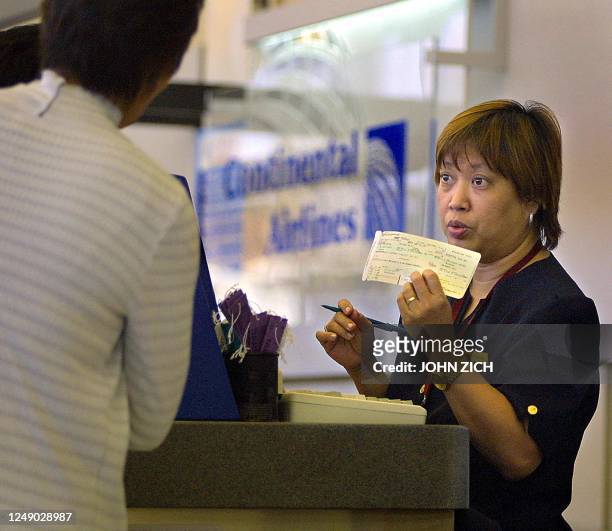 Continental Airlines ticket agent Amy Fischer checks in passengers at O'Hare International Airport in Chicago, Illinois 15 September, 2001. Due to...