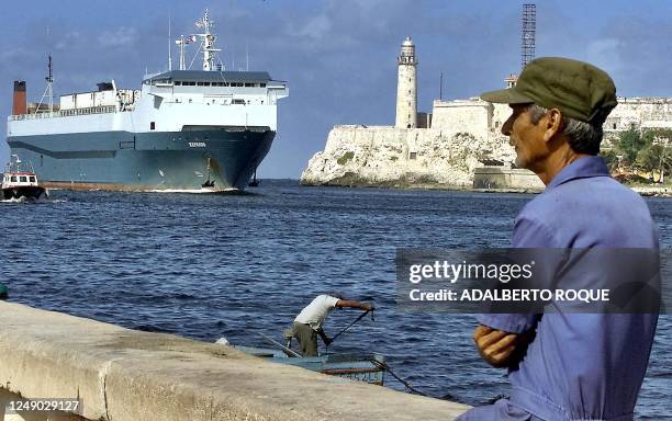 Havana resident watches as the Express container ship docks 16 December with 20 containers of frozen chicken, worth about 300,000 USD, shipped from...