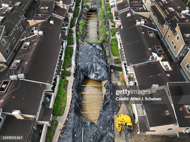 La Habra, CA A person walks their dog on a path next to a second 40-foot sinkhole that opened up after heavy rains at a La Habra condo complex amid...