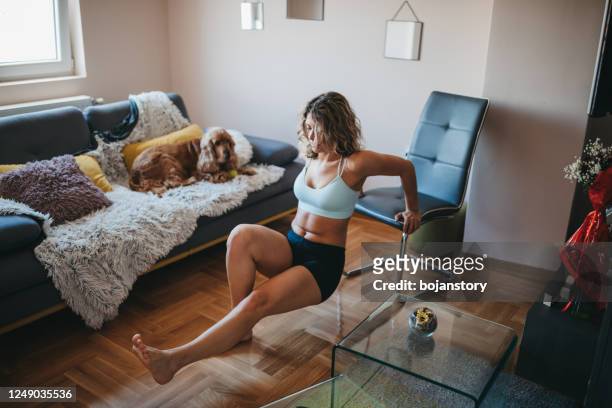 jonge vrouw met hond die thuis uitoefent - chair exercise stockfoto's en -beelden