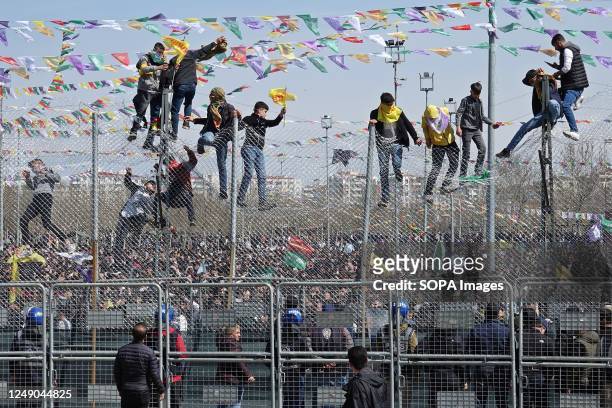 Kurdish young people protest against the Turkish police by climbing over the two-stage 5 meter high wire fences set up between them and the platform....