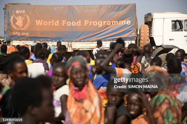 Internally displaced women wait for their food ration during a food distribution next to a World Food Programme truck in Bentiu on February 7, 2023....