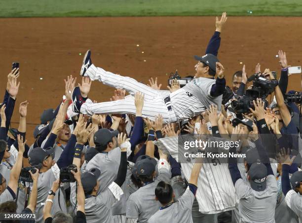 Japan players give manager Hideki Kuriyama a victory toss after beating the United States in the championship game of the World Baseball Classic at...