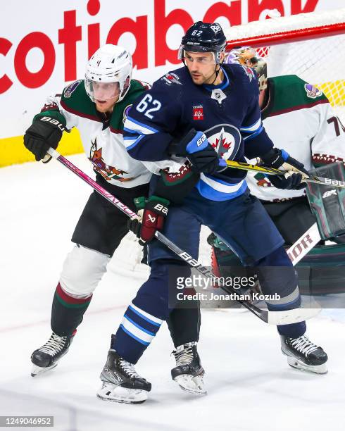 Nino Niederreiter of the Winnipeg Jets and Juuso Valimaki of the Arizona Coyotes battle for position as they keep an eye on the play during third...