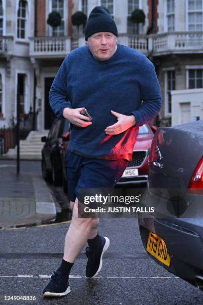 Former British Prime Minister Boris Johnson returns to his house after a run, in London on March 22, 2023. - Britain's former prime minister Boris...