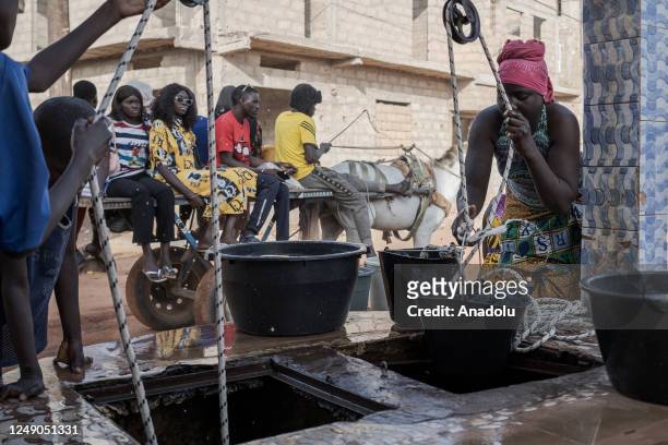 People fill buckets with clean water from a water well ahead of the World Water Day in Dakar, Senegal on March 18, 2023. World Water Day is held...