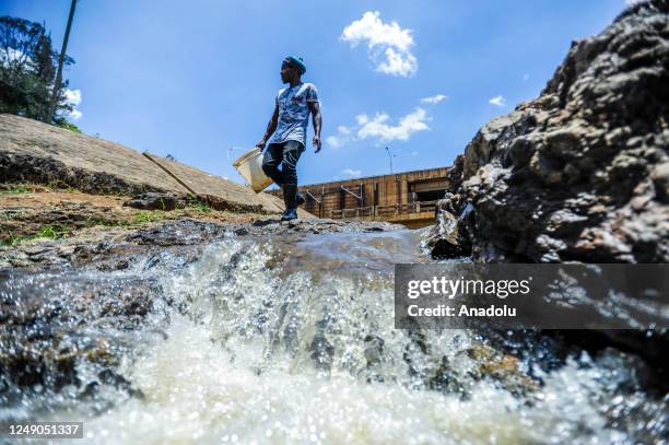 People fill buckets with water on rives located in Mathare slum in Nairobi, Kenya on March 18, 2023. World Water Day is held every year on 22 March...