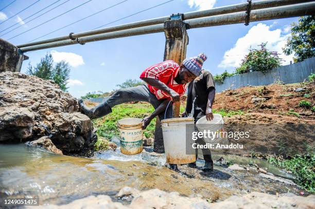 People fill buckets with water on rives located in Mathare slum in Nairobi, Kenya on March 18, 2023. World Water Day is held every year on 22 March...
