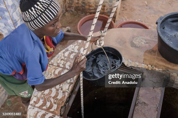 People fill buckets with clean water from a water well ahead of the World Water Day in Dakar, Senegal on March 18, 2023. World Water Day is held...