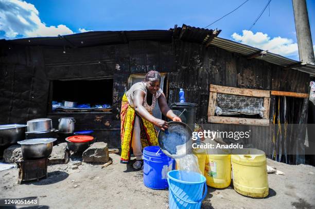 Kenyan woman fills her bucket with water near a water point located in Mathare slum in Nairobi, Kenya on March 18, 2023. World Water Day is held...