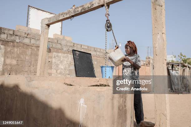 People fill buckets with clean water from a water well ahead of the World Water Day in Dakar, Senegal on March 18, 2023. World Water Day is held...