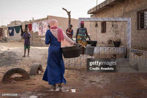 People fill buckets with clean water from a water well ahead of the World Water Day in Dakar, Senegal on March 18, 2023. World Water Day is held...