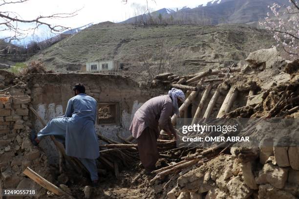 Residents clear debris from a damaged a house at Sooch village in Jurm district of Badakhshan Province on March 22 following an overnight earthquake....