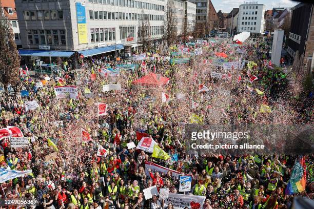 March 2023, Bavaria, Nuremberg: During the warning strike of public service employees, numerous people take part in a rally at Kornmarkt and shoot...