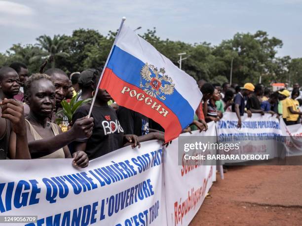 Demonstrator holds a Russian flag with the emblem of Russia on in Bangui, on March 22, 2023 during a march in support of Russia and China's presence...