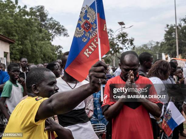 Demonstrator holds a Russian flag with the emblem of Russia on in Bangui, on March 22, 2023 during a march in support of Russia and China's presence...