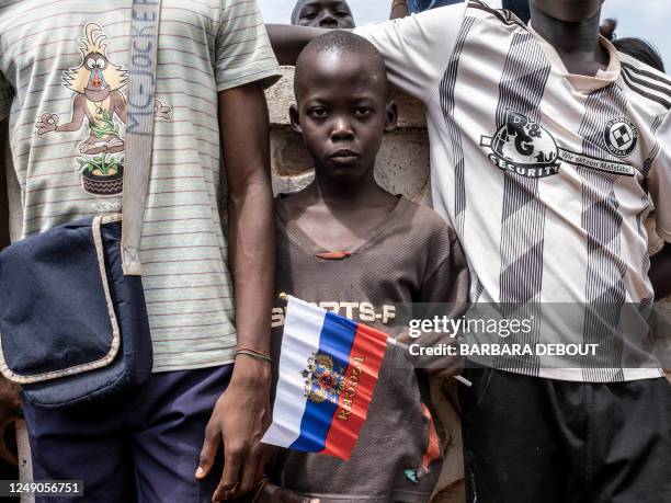 Young demonstrator holds Russian flag with the emblem of Russia on in Bangui, on March 22, 2023 during a march in support of Russia and China's...