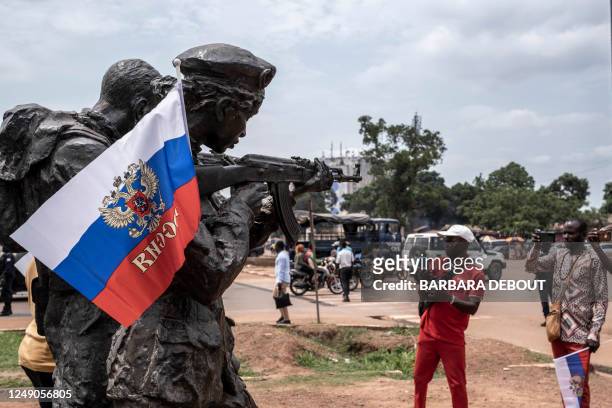 Russian flag with the emblem of Russia on hang on the monument of the Russian instructors in Bangui, on March 22, 2023 during a march in support of...