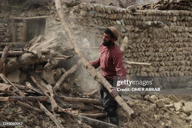 Resident clears debris from a damaged a house at Sooch village in Jurm district of Badakhshan Province on March 22 following an overnight earthquake....