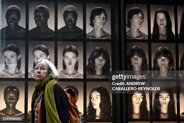 Woman walks past an advertisement in front of Trump Tower in New York City on March 22, 2023. - With barricades set up near Trump Tower and police on...