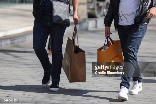 Shopper carries a Louis Vuitton branded shopping bag in Barcelona, Spain, on Wednesday, March 22, 2023. Spanish inflation unexpectedly accelerated in...