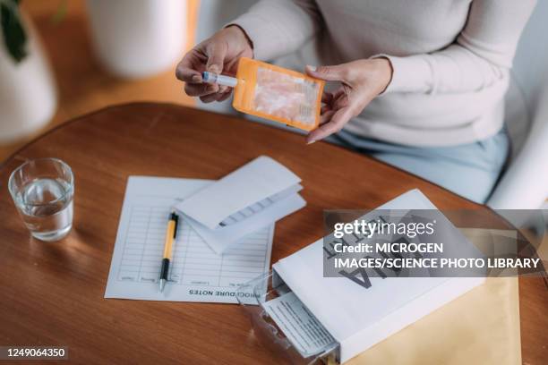 senior woman preparing dna test kit - home base stockfoto's en -beelden