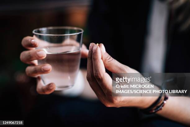 hands holding antidepressant pill and water - antidepressivo stock-fotos und bilder