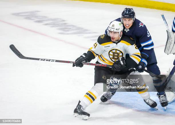 Garnet Hathaway of the Boston Bruins battles for a position in front of the net against Brenden Dillon of the Winnipeg Jets during third period...