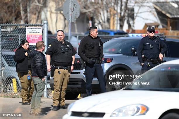 Police officers secures students parking area of Denver's East High School after a shooting at the school on Wednesday, March 22, 2023. Police said a...