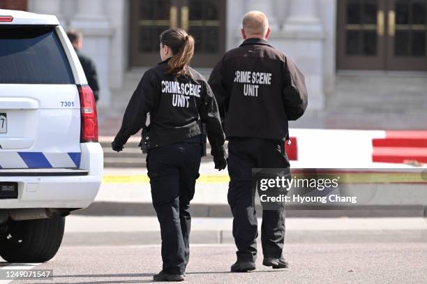 Law enforcement investigate at Denver's East High School after a shooting there on Wednesday, March 22, 2023. Police said a student shot two adult...