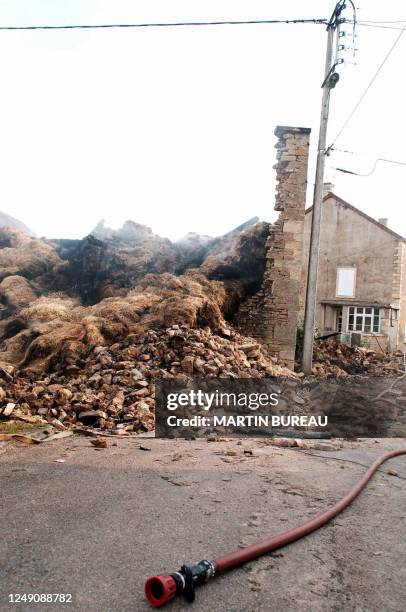 Fire nozzle lies on the ground in front of a collapsed farm building, 18 July 2005 in Metz-le-Comte. Three French firemen were killed overnight when...