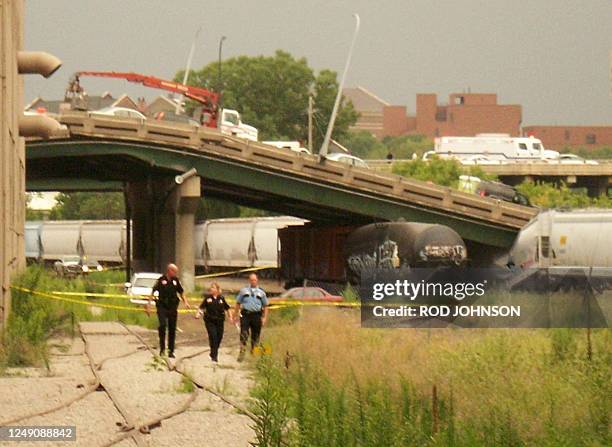 Police survey the site of a collapsed bridge over the Mississippi River 01 August 2007 in Minneapolis, Minnesota. At least six people were killed...