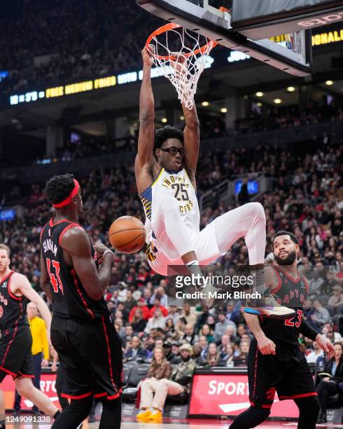Jalen Smith of the Indiana Pacers dunks against Fred VanVleet and Pascal Siakam of the Toronto Raptors during the first half of their basketball game...