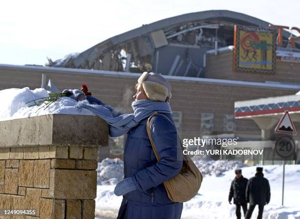 Woman lies flowers on the wall outside the water park, whose roof colapsed in Moscow, 15 February 2004. At least 24 people were killed and 110 others...