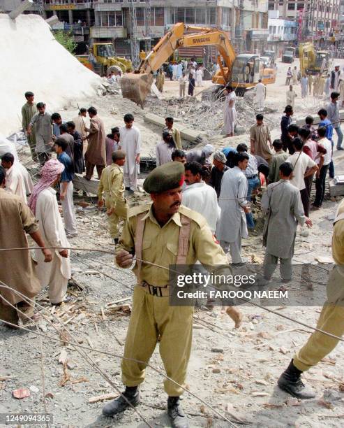 Paramilitary and rescuers work among the rubble of a collapsed building in Rawalpindi, 05 April 2003. Four people were confirmed dead Saturday and...