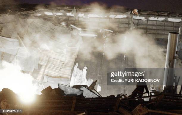 Rescuer looks at the roof collapsed on an enclosed pool in Moscow 14 February 2004. At least eight people were killed and 60 others injured when a...