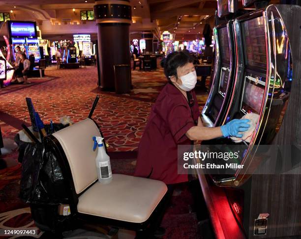 Yang Song sanitizes slot machines at Excalibur Hotel & Casino after the Las Vegas Strip property opened for the first time since being closed in...