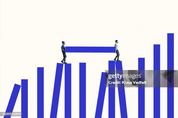 man and woman carrying blue bar on graph - uguaglianza razziale foto e immagini stock