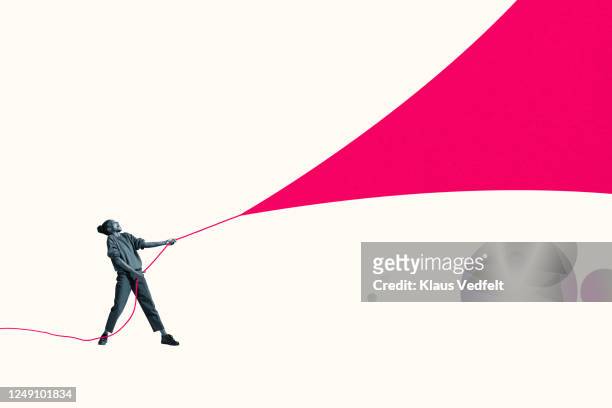 young woman pulling pink rope of large fabric - kite toy stock-fotos und bilder