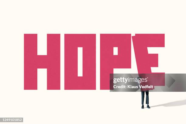 woman positioning pink block while adjusting word hope - hope word stock pictures, royalty-free photos & images