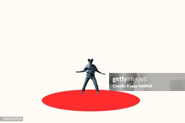 young woman standing in vibrant red ellipse - regarder vers le bas photos et images de collection