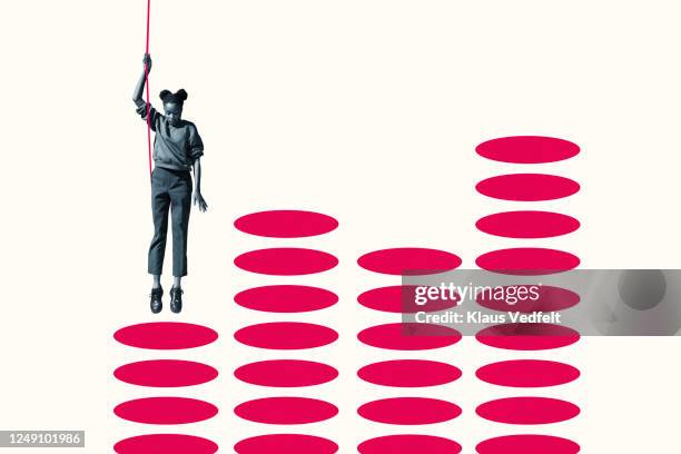 woman hanging from rope over vibrant red ellipses - same people different clothes - fotografias e filmes do acervo