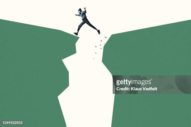 young woman jumping over green cliffs - conquering adversity stock-fotos und bilder