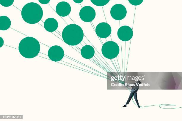 woman pulling green helium balloons with ropes - personal strength stock pictures, royalty-free photos & images