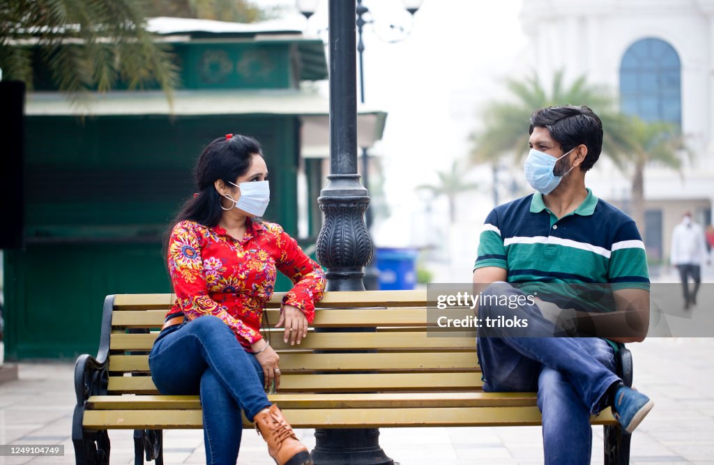 Couple sitting outdoors with social distancing