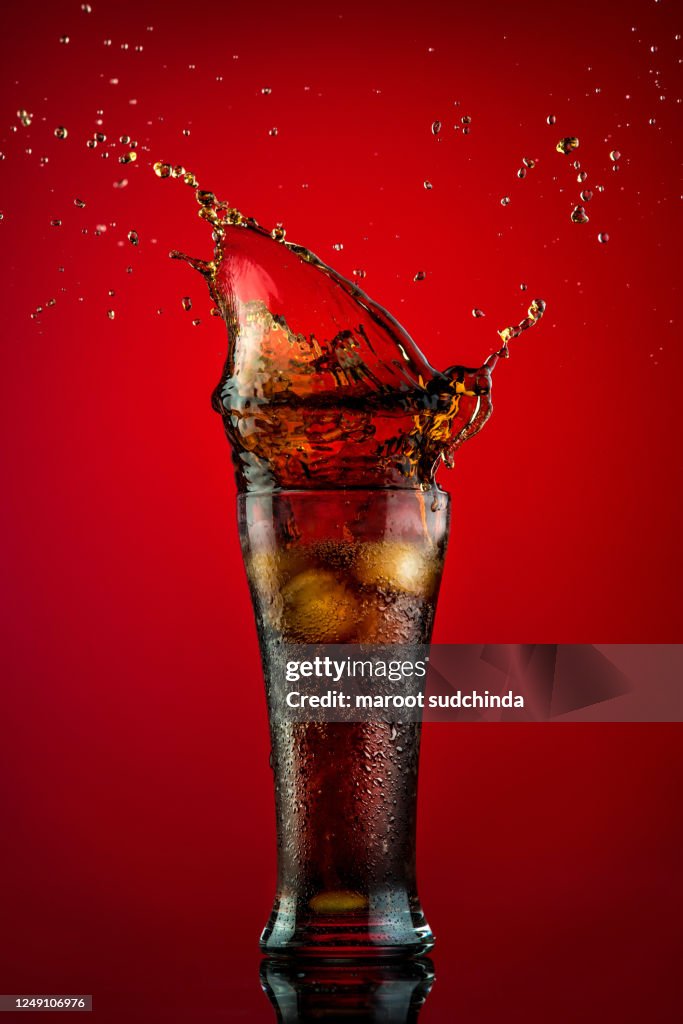 Cola splashing out of a glass.