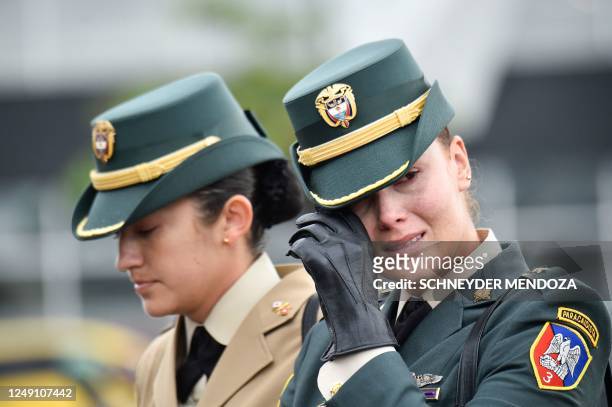 Members of Colombia's armed forces wipes a tear as she attends a military funeral ceremony for a female pilot in Cucuta, on Colombia's border with...